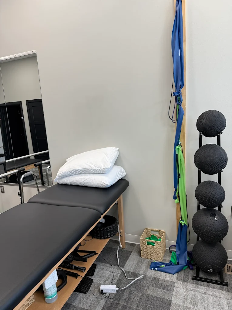 Therapy table with pillows, foam rollers, and medicine balls
